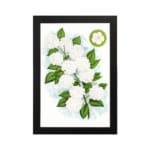 Infidu vintage wall art featuring delicate white flowers and vibrant green leaves against a white background hung on the wall on a white background
