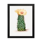Vintage wall art of a cactus with a yellow flower in bloom, set against a light cream background, framed in black. hung on the wall