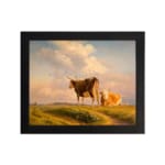 Vintage wall art showing two cows in a grassy field beneath a warm, glowing sky with rolling hills in the background. hung on the wall