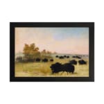 Infidu vintage wall art featuring a calm pastoral scene with black cattle grazing on a green field under a soft, cloudy sky. hung on the wall on a white background