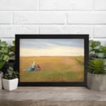 Vintage wall art of two women sitting in an open field under a bright, cloudy sky with soft green and yellow tones. displayed on the wall