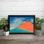 Vintage wall art of Mount Fuji by Hokusai with red mountain, blue sky, and white clouds. displayed on the wall