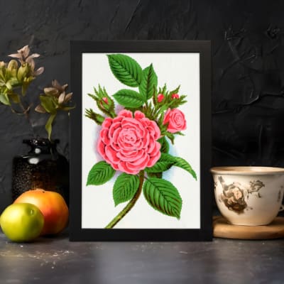Infidu vintage wall art with blooming pink rose and green leaves in a classic black frame. displayed on the wall