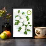 Infidu vintage wall art featuring delicate white flowers and vibrant green leaves against a white background displayed on the wall art in a black frame