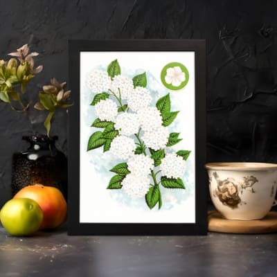 Infidu vintage wall art featuring delicate white flowers and vibrant green leaves against a white background displayed on the wall art in a black frame