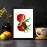 Vintage wall art featuring ripe red peaches with green leaves and a clean white background. displayed on the wall