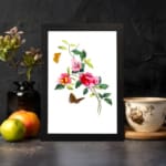 Vintage art of pink and red flowers with green leaves, two orange and brown butterflies, framed in black. displayed on the wall