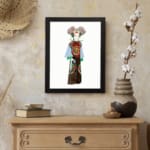 Vintage wall art of a person in traditional clothing with colorful robe and detailed headpiece, framed in black. displayed on the wall