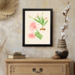Vintage wall art with pink flowers and green cactus stems in a brown pot, set against a beige background with a clean black frame. displayed on the wall