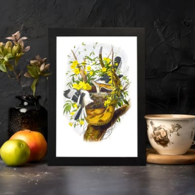 Vintage wall art showing two black and white birds flying near a tree branch with green leaves and bright yellow flowers on a white background. displayed on the wall