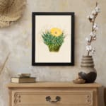 Infidu Vintage Cactus & Yellow Flower Wall Art showcasing a vibrant cactus plant with a yellow flower, framed in black. displayed on the wall