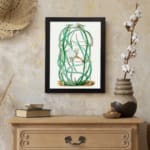 Vintage botanical wall art of a cactus with twisting green stems and a white flower, framed in black. displayed on the wall