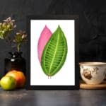 Vintage wall art featuring a green and pink leaf print with detailed veins and a white background. displayed on the wall
