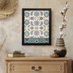 Vintage Persian floral and geometric wall art print with blue, teal, and purple flowers on a cream background in a black frame. displayed on the wall