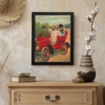 Vintage wall art of red antique car with four people in early 20th-century clothing, riding through the countryside. displayed on the wall in a black frame