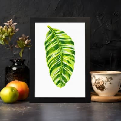 Bright green leaf with light and dark tones on white background in a black frame – vintage wall art by Infidu. displayed on the wall