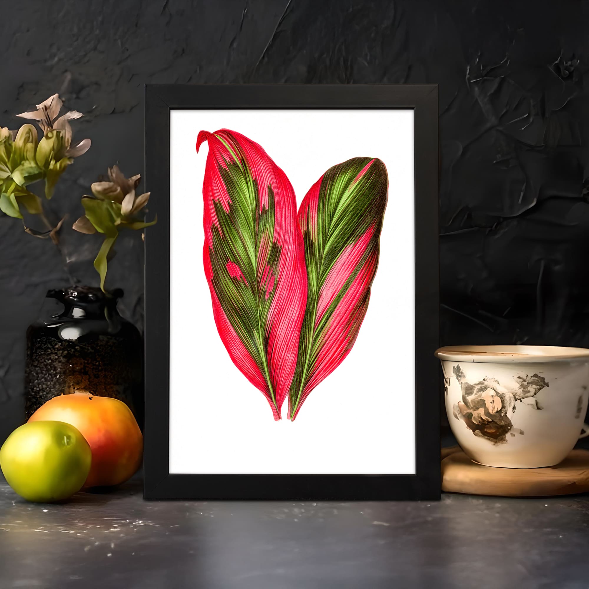 Vintage wall art with two colorful leaves in red and green on a white background with a black frame. displayed on the wall in a black frame