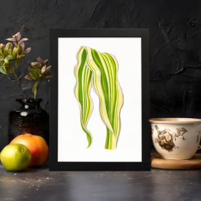 Vintage wall art of a single leaf with flowing, wavy shapes in green and yellow, framed in black on a white background. displayed on the wall
