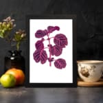 Vintage wall art showing a purple leafy plant with pink veins on a white background, framed in black. displayed on the wall