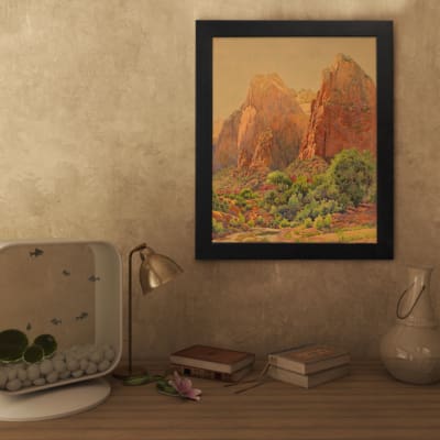 Infidu Rustic Mountain Scene vintage wall art showing mountains with reddish-brown cliffs, green trees, and a golden-yellow sky. displayed on the wall