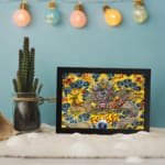 Infidu vintage wall art featuring a majestic dragon in gold, red, and silver tones, surrounded by blue clouds and fiery red flames on a vibrant yellow background. displayed on the wall art in a black frame