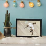 Infidu vintage wall art featuring a graceful hummingbird in flight against a soft brown background with soothing, natural tones. displayed on the wall art in a black frame