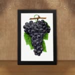 Vintage wall art print of dark purple grapes with green leaves on a white background. displayed on the wall