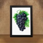 Vintage wall art of dark purple grapes with green leaves on a white background. displayed on the wall