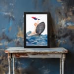 Vintage wall art of a woman riding a seashell over bold ocean waves with red and blue cloth, in a dramatic and whimsical seaside scene. displayed on the wall