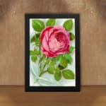 Infidu vintage wall art with a pink rose in full bloom and green leaves on a soft watercolor background. displayed on the wall