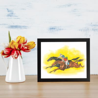 Vintage horse racing wall art with two galloping horses and jockeys on a bold yellow background. displayed on the wall