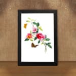 Vintage art of pink and red flowers with green leaves, two orange and brown butterflies, framed in black. displayed on the wall