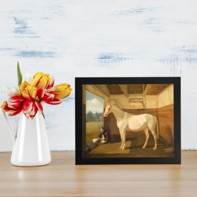 Vintage wall art of a white horse standing calmly inside a rustic wooden stable with a peaceful countryside view. displayed on the wall