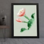 Vintage botanical wall art with a blooming flower and detailed green leaves, framed in black. displayed on the wall