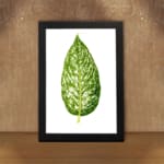 Vintage leaf wall art with a large green marbled leaf centered on a white background, framed in black displayed on the wall