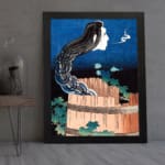 Vintage wall art of a ghostly face with long black hair emerging from a wooden barrel, with a dramatic night sky background. displayed on the wall in a black frame