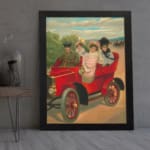 Vintage wall art of red antique car with four people in early 20th-century clothing, riding through the countryside. displayed on the wall in a black frame
