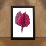 Vintage wall art featuring two overlapping leaves in red and purple on a white background with a black frame. displayed on the wall