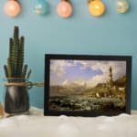 Vintage coastal wall art with waves, a lighthouse, and mountains. displayed on the wall