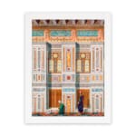 Vintage architectural wall art with two traditional figures, colorful tile patterns, and detailed building elements in a white frame. hung on the wall