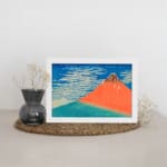 Vintage wall art of Mount Fuji by Hokusai with red mountain, blue sky, and white clouds. displayed on the wall