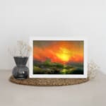 Infidu vintage ocean sunset wall art with fiery sky, waves, and glowing sun in bold colors of orange, red, yellow, and green. displayed on the wall