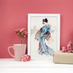 Vintage wall art of a Japanese woman in a soft blue kimono with a fan, styled with calm brush strokes and traditional details. displayed on the wall