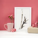 Vintage ink bamboo wall art in Zen brush style with black and gray tones on a white background. displayed on the wall
