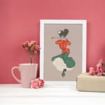 Vintage wall art of a dancing woman in red top and green dress with a beige background, inspired by classic early 1900s poster style. displayed on the wall