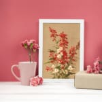 Vintage botanical wall art with red and white flowers and green leaves on a tan background. displayed on the wall