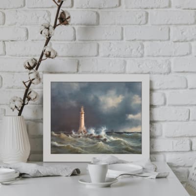 Vintage wall art of a lighthouse in stormy seas with dramatic blue and gray tones. displayed on the wall in a white frame