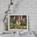 Vintage wall art of a brown rabbit sitting in a lush green forest with trees and plants in the background. displayed on the wall