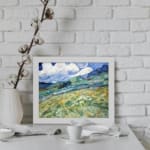 Infidu vintage countryside wall art with green hills and swirling blue sky. displayed on the wall
