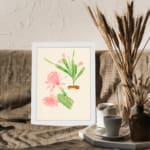 Vintage wall art with pink flowers and green cactus stems in a brown pot, set against a beige background with a clean white frame. displayed on the wall